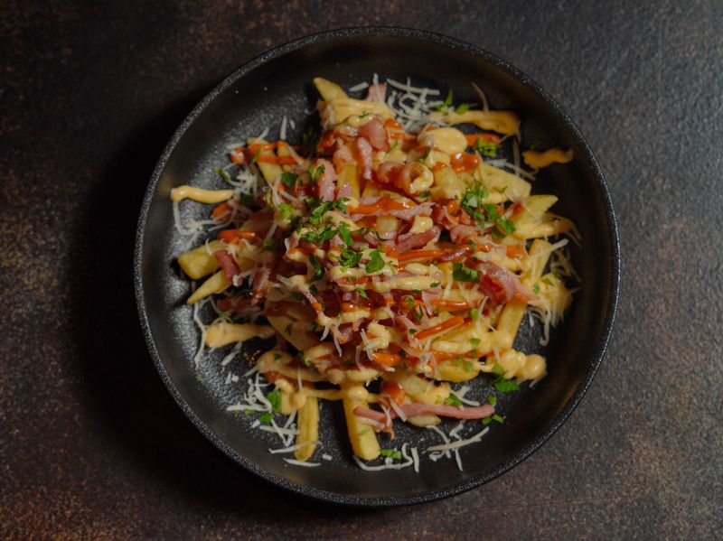 Loaded cheese fries with bacon bits and sour cream